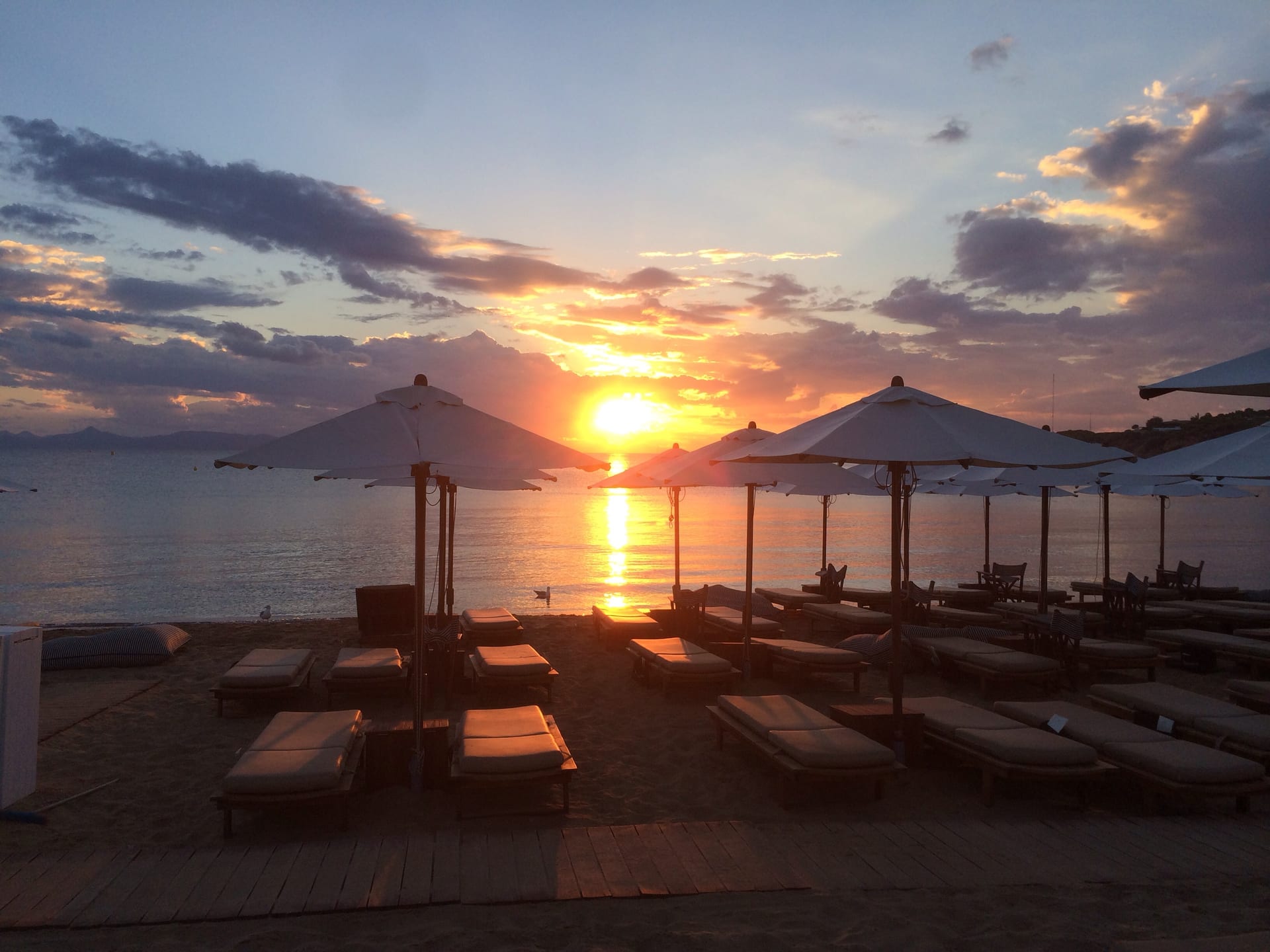 Sun loungers and umbrellas at sunset on Astir Beach in Vouliagmeni, on the Athens Riviera.