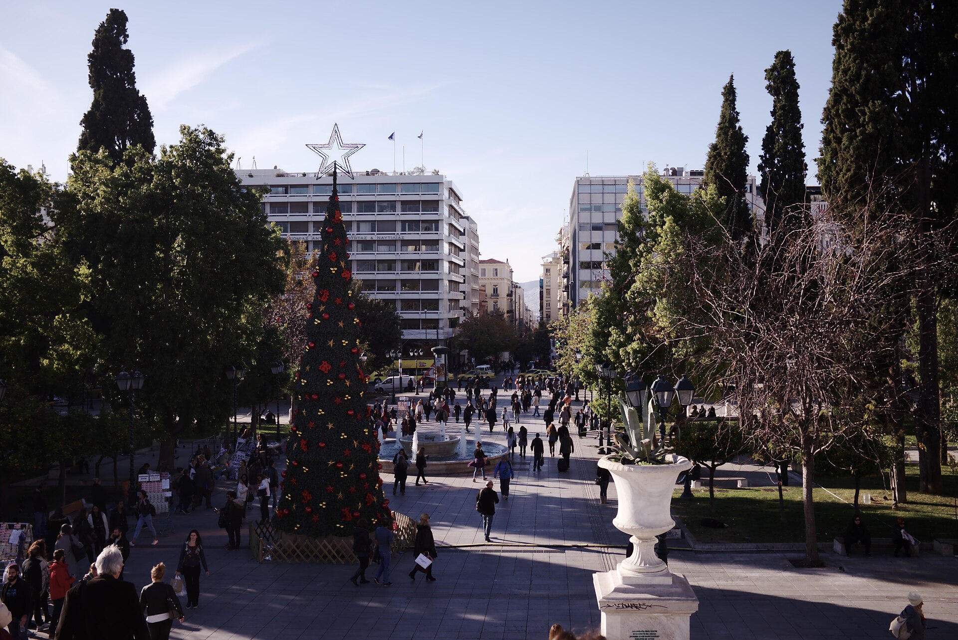 Syntagma Square in central Athens with trees, traffic, and the city rising behind it.