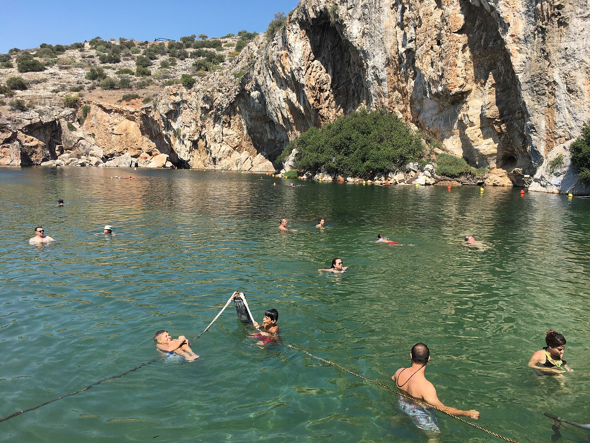 Lake Vouliagmeni on the Athens Riviera surrounded by limestone cliffs.